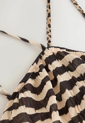 Dzīvnieku raksta tops ar piedurknēm, melnā un bēšā krāsā, regulējamas lencītes un gluda tekstūra.