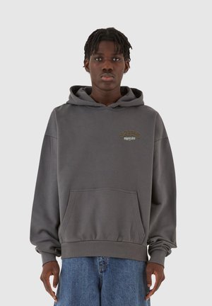 Grå pullover hoodie lavet af blødt stof, med en frontlomme, ribbede manchetter og et trykt logo i guld på brystet.