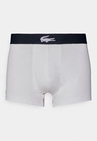Vita boxershorts med en åtsittande design, elastisk svart midjeband med en ljusgrå krokodil-logotyp och en slät tygkvalitet.