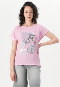 Pink short-sleeved t-shirt with a loose fit, featuring a graphic design of a line drawing and flowers. The text “glow” is metallic.