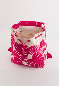 Bolso de lona tipo cubo con bordado de hojas tropicales en rosa, cordón y detalles en rosa. Interior forrado con tela beige y bolsillo con cremallera.
