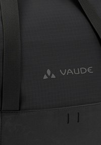 Schwarzer Stoff-Rucksack mit einer strukturierten Oberfläche, markanten Nähten und einem aufgedruckten Logo. Enthält strapazierfähige Träger zum Tragen.