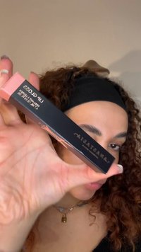 Lipglossverpakking met een strakke zwarte tube met roze accenten en witte tekst. De doos toont de merknaam "Anastasia".