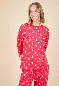 Camisa de pijama roja de manga larga con un estampado divertido de calcetines, gafas y estrellas; combinada con pantalones a juego con el mismo estampado. Tejido suave, corte relajado.