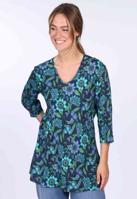 Floral tunic top with a V-neck, featuring a navy background, green leaves, and vibrant blue flowers, made from lightweight fabric.