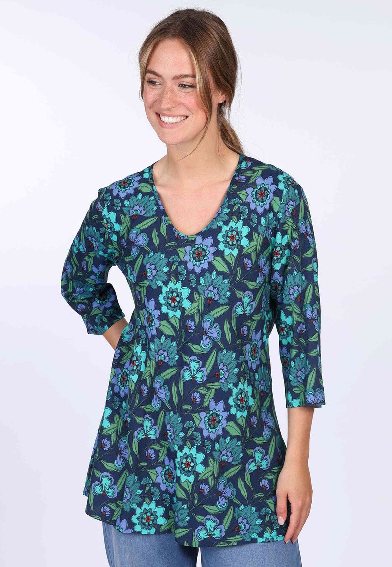 Floral tunic top with a V-neck, featuring a navy background, green leaves, and vibrant blue flowers, made from lightweight fabric.