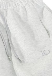 Lichtgrijze sweatpants van zachte stof, met een elastische tailleband, grijze trekkoorden met zilveren uiteinden en een klein nummer "10" erop gedrukt.