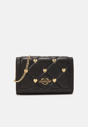 Bolso negro de cuero acolchado con tachuelas doradas en forma de corazón, correa de cadena dorada y logotipo "Love Moschino" centrado en la solapa frontal.