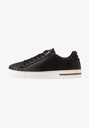 Czarne skórzane sneakersy z białą gumową podeszwą. Charakteryzują się zaokrąglonym noskiem, sznurowanym designem oraz korkowym akcentem na śródpodeszwie.