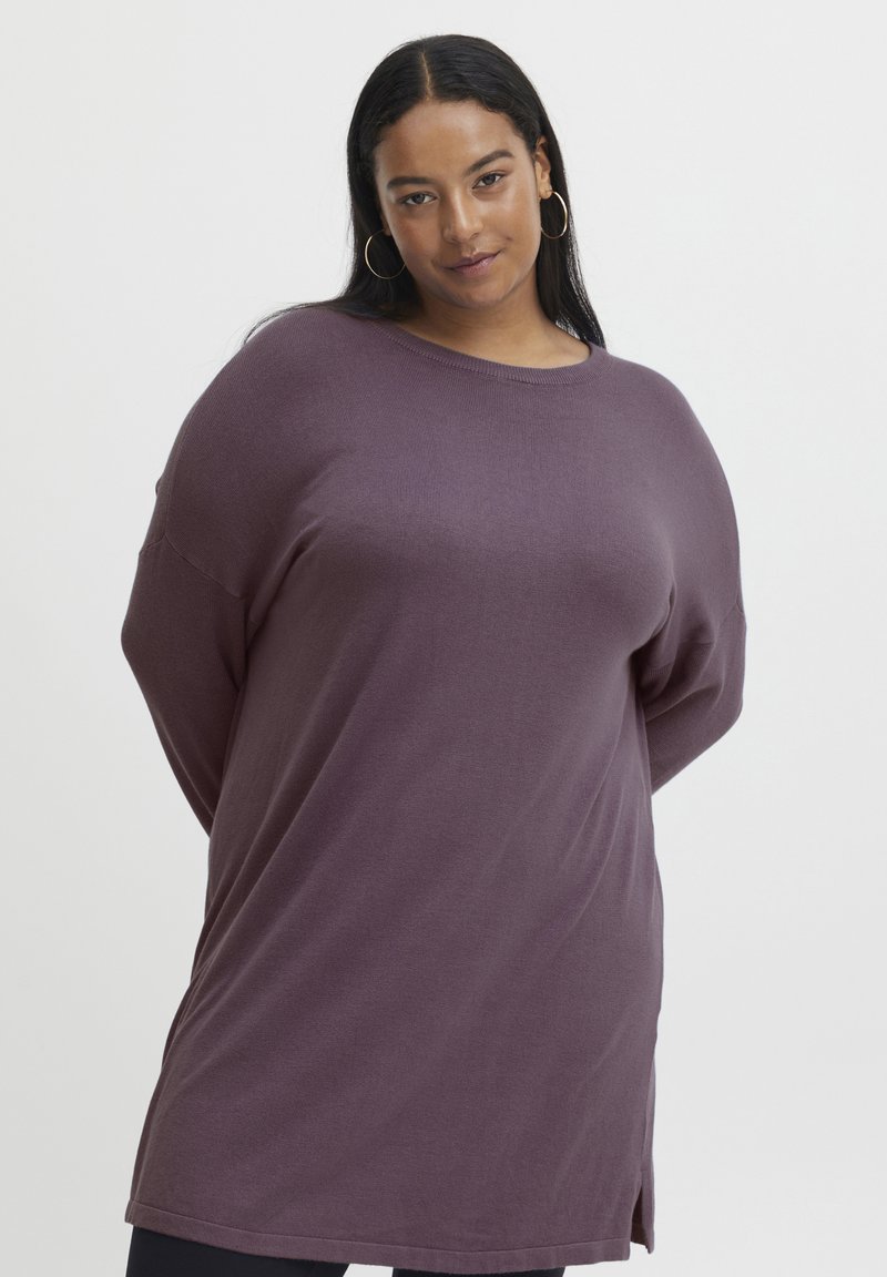 Hanorac oversized de culoare purpurie, cu mâneci lungi și guler rotund. Confectat dintr-un material moale, cu o fanta laterală la tiv pentru un plus de mobilitate.