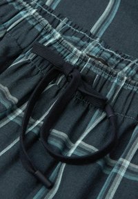 Niebieskie szorty w kratę z dżerseju z czarnym sznurkiem, wykonane z miękkiego materiału z jasnoniebieskimi i białymi wzorami w kratę.