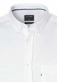 Weißes Hemd mit Knopfleiste, regulären Schnitt, klassischem Kragen und einer Brusttasche. Weicher Stoff mit feiner Textur und navyfarbenen Details am inneren Kragen.