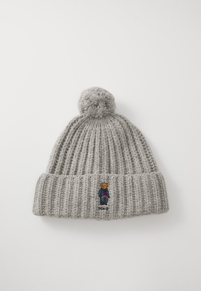 Grå strikket lue med ribbestruktur, toppet med en dusk. Har et brodert design av en teddybjørn og "Polo"-tekst på kanten.