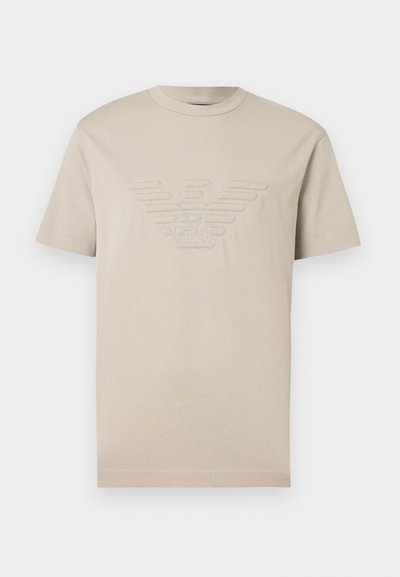 Μπεζ κοντομάνικο T-shirt με κεντημένο λογότυπο αετού και τα αρχικά "GA" στο κέντρο του στήθους.