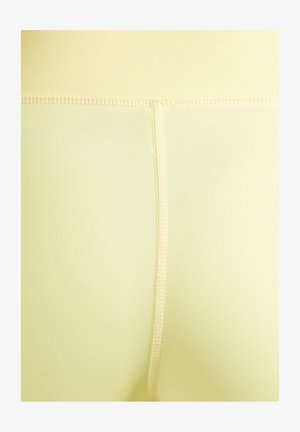 Gele legging met een gladde textuur, voorzien van een hoge tailleband en platte naden voor comfort. De stof lijkt elastisch en nauwsluitend.