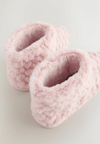 Lyserøde pels-tøfler med quiltet tekstur, rund form og blød indvendig foring. Tyk, blød materiale giver varme og komfort.