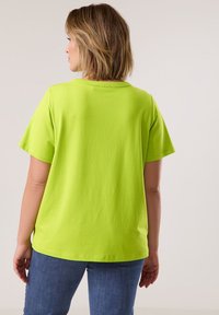 Bright green short-sleeved t-shirt with a relaxed fit, featuring a wide crew neckline and smooth cotton texture. Back view shown.