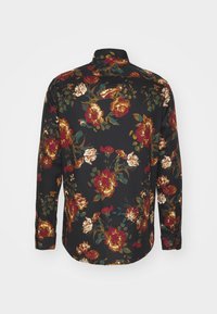 Långärmad skjorta i svart tyg med ett blommönster med röda, gyllene och gröna accenter; standardkrage och knäppte manschetter.