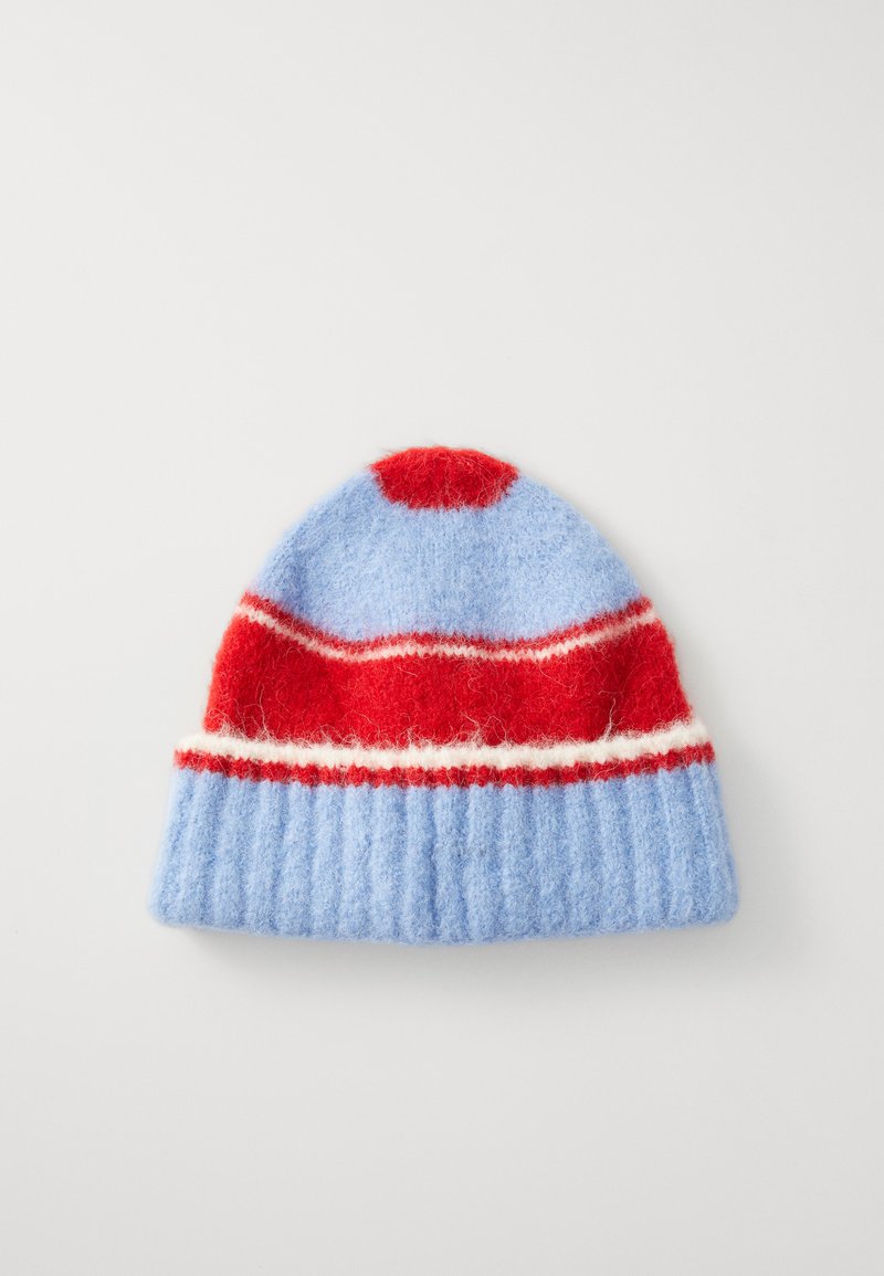 Ullstrikket hatt i lyseblått, med et rødt og hvitt stripete bånd og en rød pom-pom på toppen. Har et ribbestrikket, oppbrettet design.