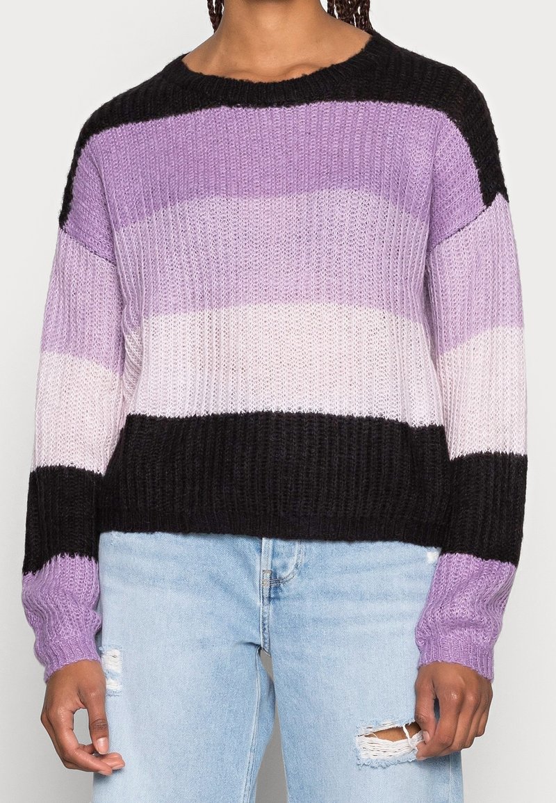 Sweter w paski z naprzemiennymi pasami w jasnym fiolecie, ciemnym fiolecie, bieli i czerni. Faktura prążkowana, dekolt typu crew i długie rękawy.