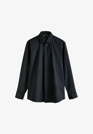 Zwarte langozijde shirt van soepel materiaal, met een klassieke kraag, knoopsluiting aan de voorkant en twee verticale naden op de borst voor een designkenmerk.