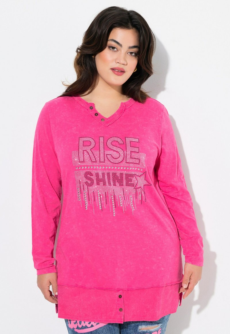 Felpa a maniche lunghe rosa con scollatura a V, impreziosita da scritte "RISE SHINE" in strass, e un orlo arrotondato con dettagli di bottoni nella parte inferiore.