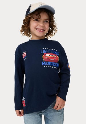 T-shirt à manches longues bleu marine avec un graphique de Lightning McQueen, col rond, avec des accents imprimés et une texture douce. Associé à un denim clair.