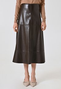 Brauner Leder-Midirock mit einer glatten Textur, der eine hohe Taille, eine A-Linien-Silhouette und dezente Nähte aufweist.