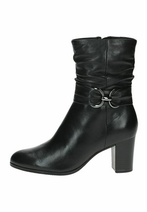 Bottine en cuir noir avec un design décontracté, ornée d'une quincaillerie en métal argenté autour de la cheville et d'un talon épais.