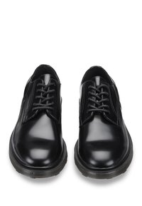 Scarpe di pelle nera con finitura lucida, punta rotonda, design tradizionale con lacci e suola in gomma testurizzata per una migliore aderenza.