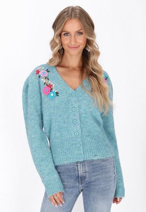 Cardigan azzurro chiaro in maglia con scollo a V, caratterizzato da ricami floreali su una spalla e cinque bottoni frontali. Maniche lunghe con polsini a costine.