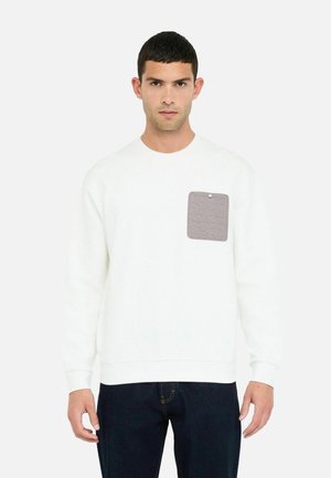 Sweatshirt blanc avec un col rond, présentant une poche plaquée grise texturée sur la poitrine gauche. Manches et ourlet côtelés. Coupe décontractée.