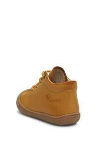 Scarpa alta in pelle tan con una consistenza morbida, chiusura con lacci e suola in gomma. Presenta un logo impresso sul lato esterno.