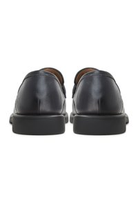 Zwarte leren schoenen met een gladde textuur en een afgeronde neus, voorzien van een stevige zwarte rubberen zool en minimale stikseldetails.