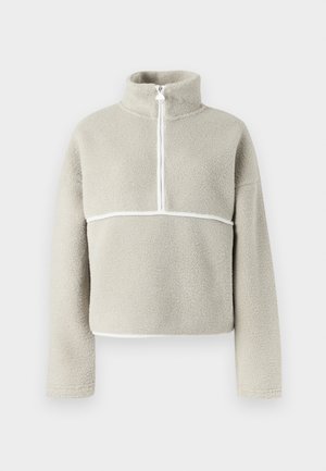 Pulover din fleece gri deschis, cu guler înalt, fermoar de un sfert și margine albă pe piept și mâneci; textură moale, croială lejeră.