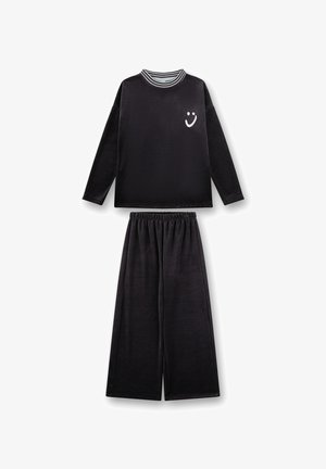 Black loungewear set featuring a long-sleeve top with a striped collar and smiley face graphic, paired with wide-leg pants. Soft texture.