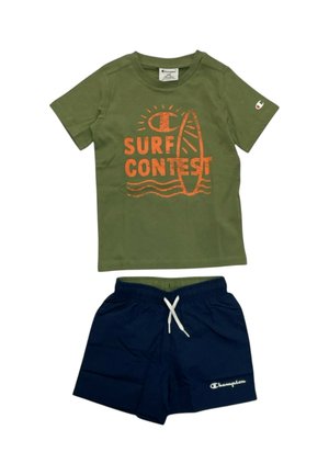 T-shirt verde a manica corta con scritta arancione "Surf Contest" e grafica di una tavola da surf, abbinata a pantaloncini blu navy con coulisse e logo bianco Champion.