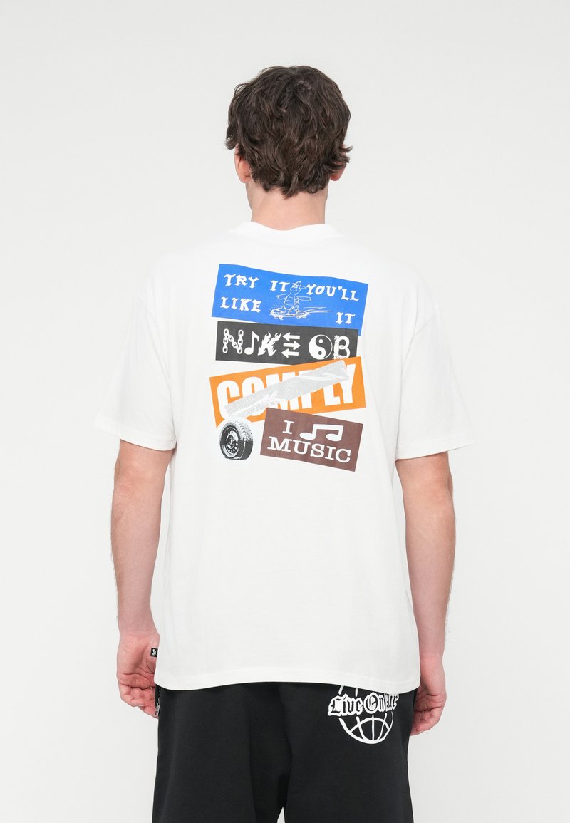 Λευκό βαμβακερό t-shirt με πολύχρωμο γραφικό τύπωμα στην πλάτη με κείμενο και εικόνες σε μπλε, πορτοκαλί, μαύρο και καφέ.