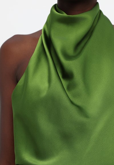 Green satin top with a smooth texture, featuring draped fabric at the neckline and asymmetrical shoulder style.