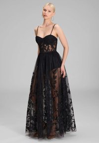Schwarz Abendkleid mit einem figurnahen Oberteil, verziert mit Spitzenapplikationen und einem geschichteten Tüllrock, der mit floralem Stickerei und transparenter Textur geschmückt ist.
