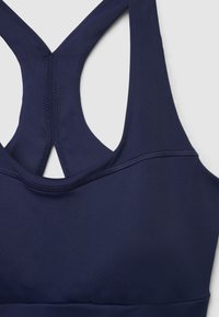 Marineblauer Sport-BH mit Racerback-Design und verstärkten Nähten auf hellem Hintergrund.