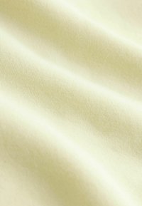 Zachte, gestructureerde stof in lichtgeel, met een gladde, licht rekbare weving en fijne, gelijkmatige stiksels. Ideaal voor diverse textieltoepassingen.