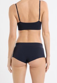 Marineblauer BH und passende Boyshorts aus glattem Stoff, mit verstellbaren Trägern, strukturierten Mustern und einem bequemen Bund.