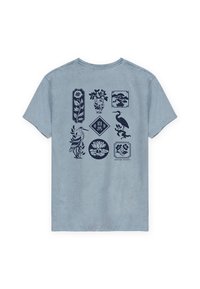 Camiseta de algodón azul claro con diseños impresos en azul oscuro de flores, plantas y pájaros dispuestos en marcos en la parte posterior.