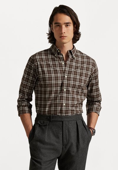 Brun ternet skjorte med knapper, der har en krave, lange ærmer og en slim fit, parret med grå plisserede bukser.