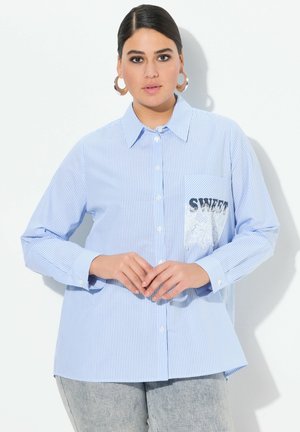 Camisa a rayas azul y blanca con cuello abotonado, mangas largas, un bolsillo con encaje y el texto "SWEET" en negro.