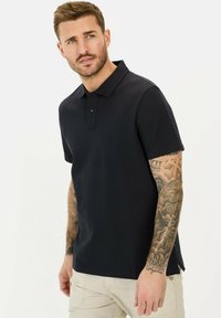 Marineblå kortærmet polo-shirt med tekstureret stof, tre-knaps lukning og slidser i kanten for forbedret pasform og komfort.