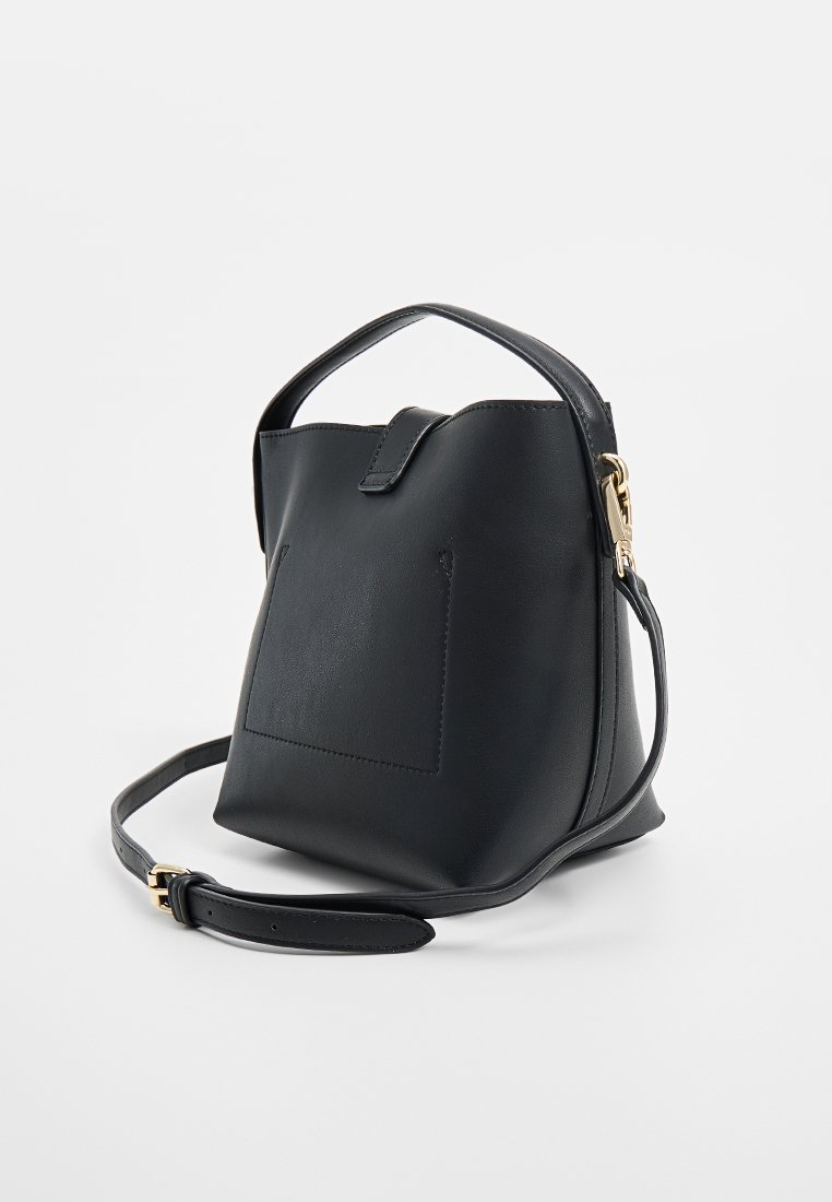 Sac à main en cuir noir avec un design structuré et effilé. Il dispose d'une anse supérieure unique et d'une bandoulière ajustable. Petite poche avant.