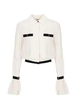 Blusa bianca a maniche lunghe con rifiniture nere sulle tasche del petto, sui polsini e in vita, caratterizzata da maniche arricciate e dettagli con bottoni.