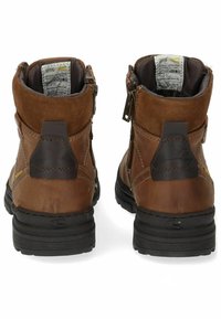 Bottines en cuir marron avec des accents en daim, fermeture à glissière et semelles en caoutchouc. Dispose d'une languette arrière grise et d'un détail de marque sur le côté.